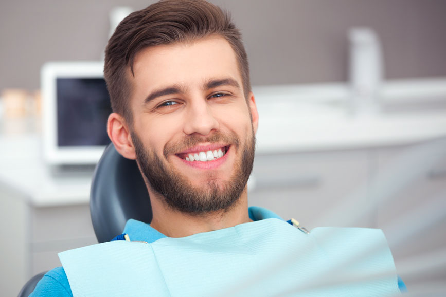 Man Sitting On A Dental Chair With A Smile On His Face