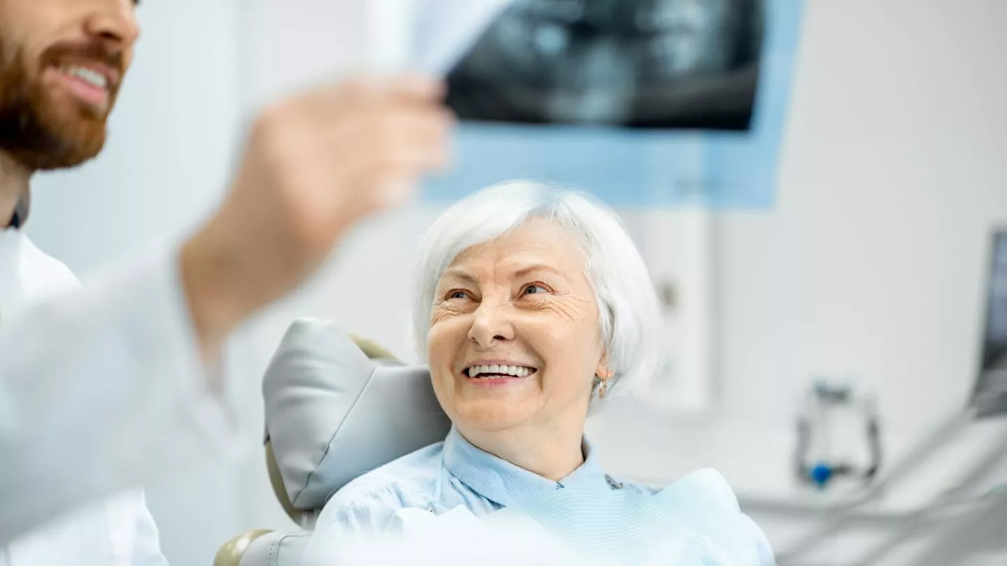 A Senior Smiling At A Dentist