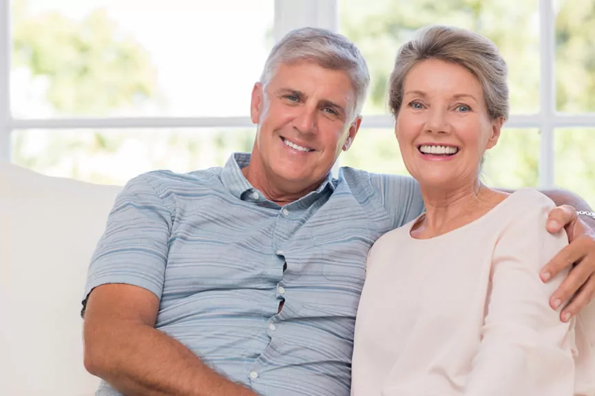 Elderly Couple Smiling After Dental Implant