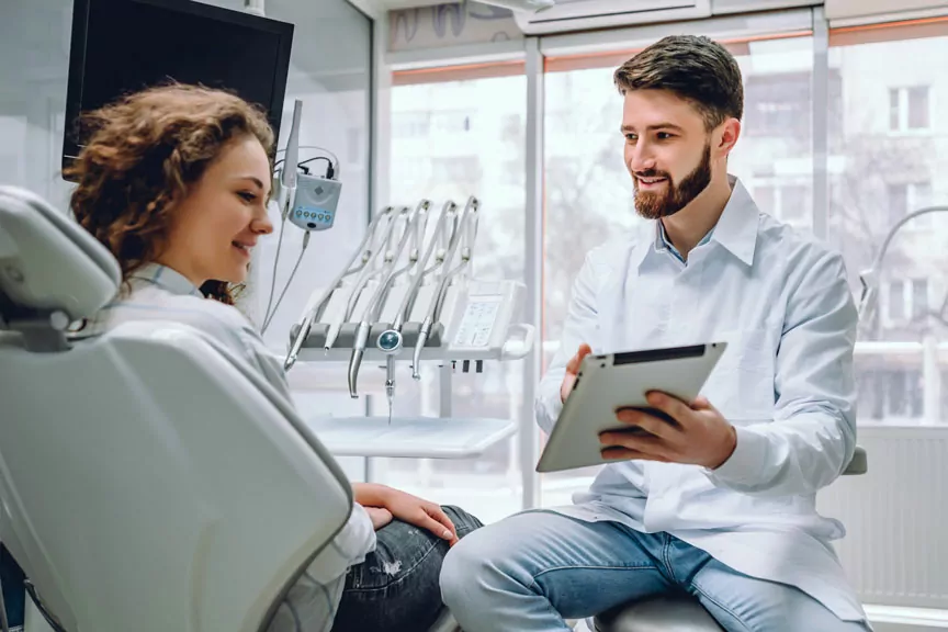 A Dentist Explaining A Dental Procedure To A Patient