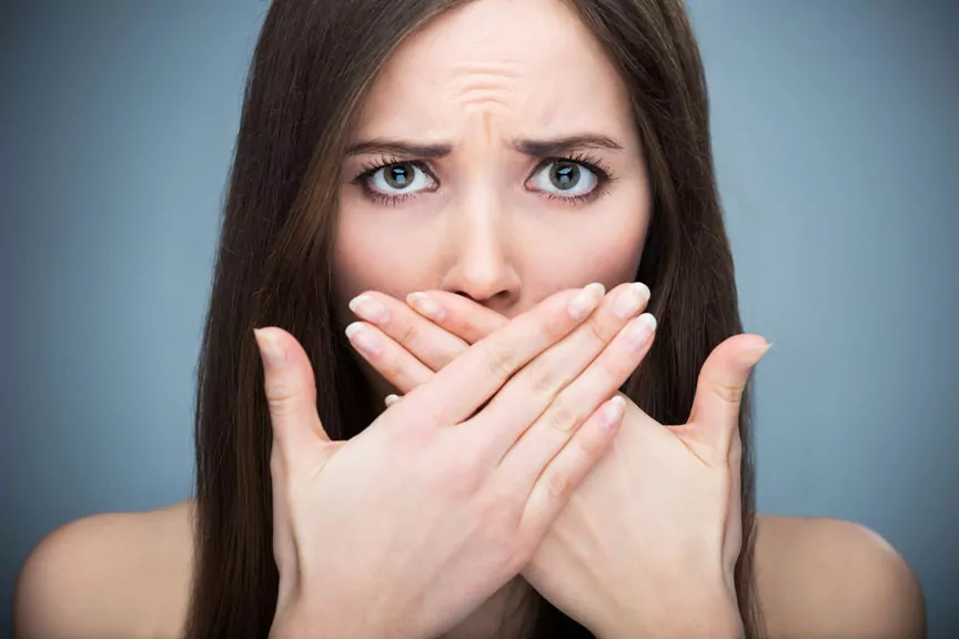 A Worried Woman Covering Her Mouth With Both Hands