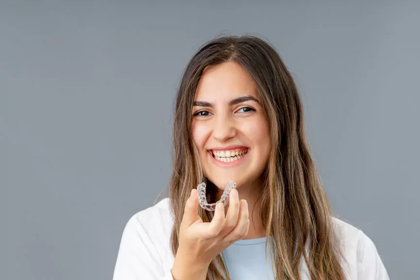 Woman Holding Clear Dental Aligner