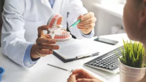 Dentist Pointing to Jaw Model With Patient